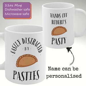 May include: White ceramic mug featuring the text "EASILY DISTRACTED BY PASTIES" and a pasty illustration. Another mug shows "HANDS OFF ROBERT'S PASTY". The mug is 312ml and is dishwasher and microwave safe. Personalisation is available.