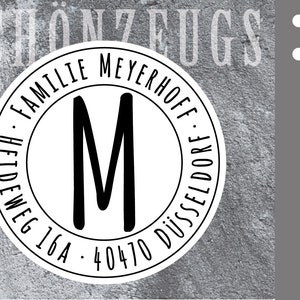 Könnte beinhalten: Schwarz-weißer runder Stempel mit dem Text "Familie Meyerhoff Heideweg 16A - 40470 Düsseldorf" und dem Buchstaben "M" in der Mitte.