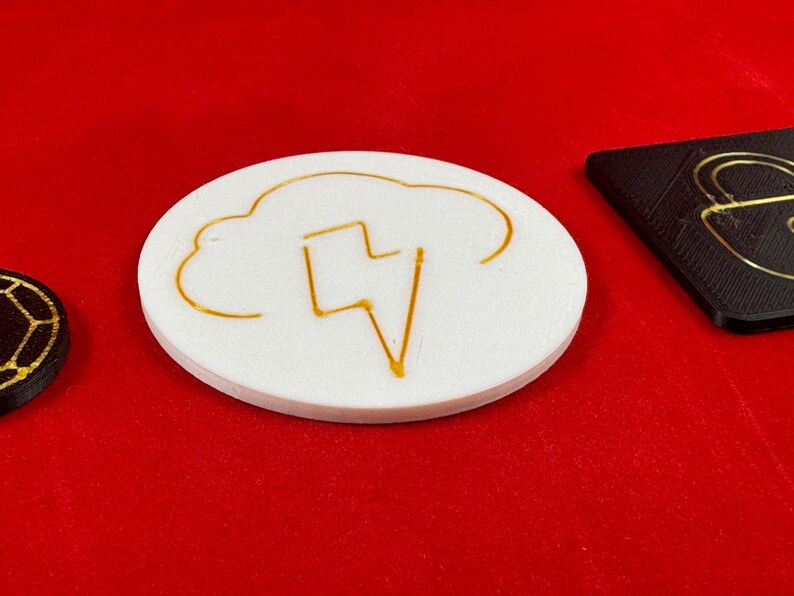 May include: A white round coaster with a gold lightning bolt inside a cloud design.