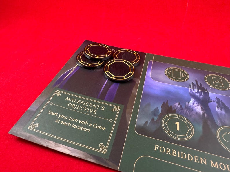 May include: A green game board with a black and gold card that reads "Maleficent's Objective: Start your turn with a Curse at each location."  There are four black and gold tokens on the board.