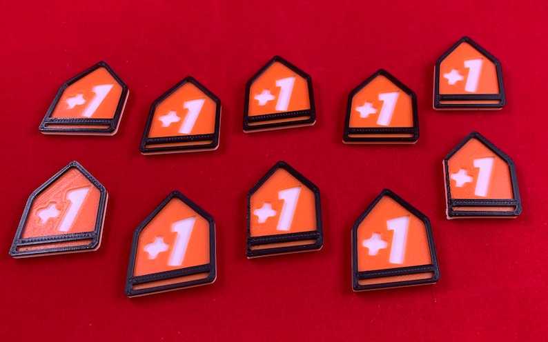 Op de afbeelding: Tien oranje en zwarte plastic tokens met een wit plusteken en het nummer &eacute;&eacute;n op elk.
