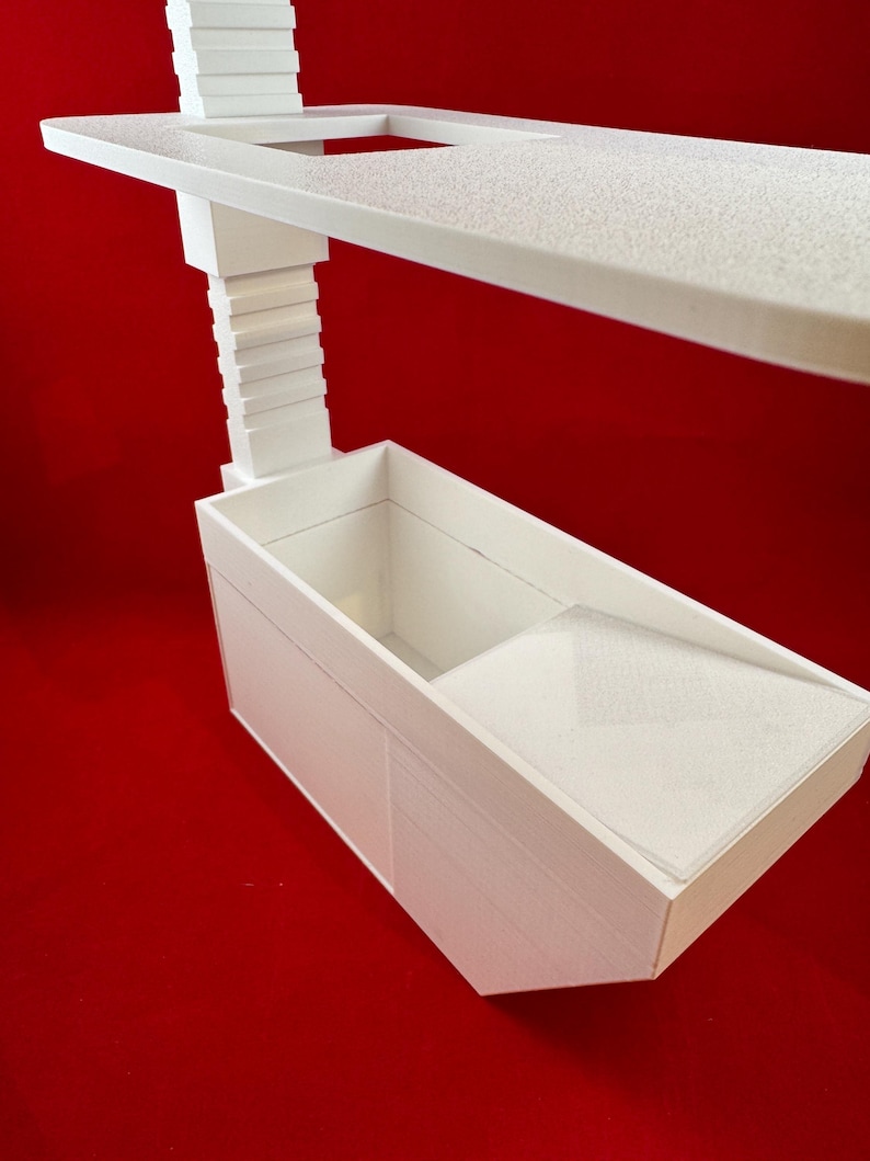 May include: White plastic shelf unit with a small rectangular tray and a larger rectangular tray below. The shelf unit is designed to be mounted on a wall.