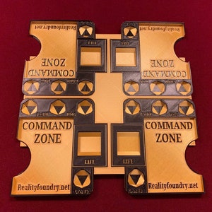 May include: A brown wooden game board with black and gold accents. The board has two sections labeled "Command Zone" and features the text "Realityfoundry.net".