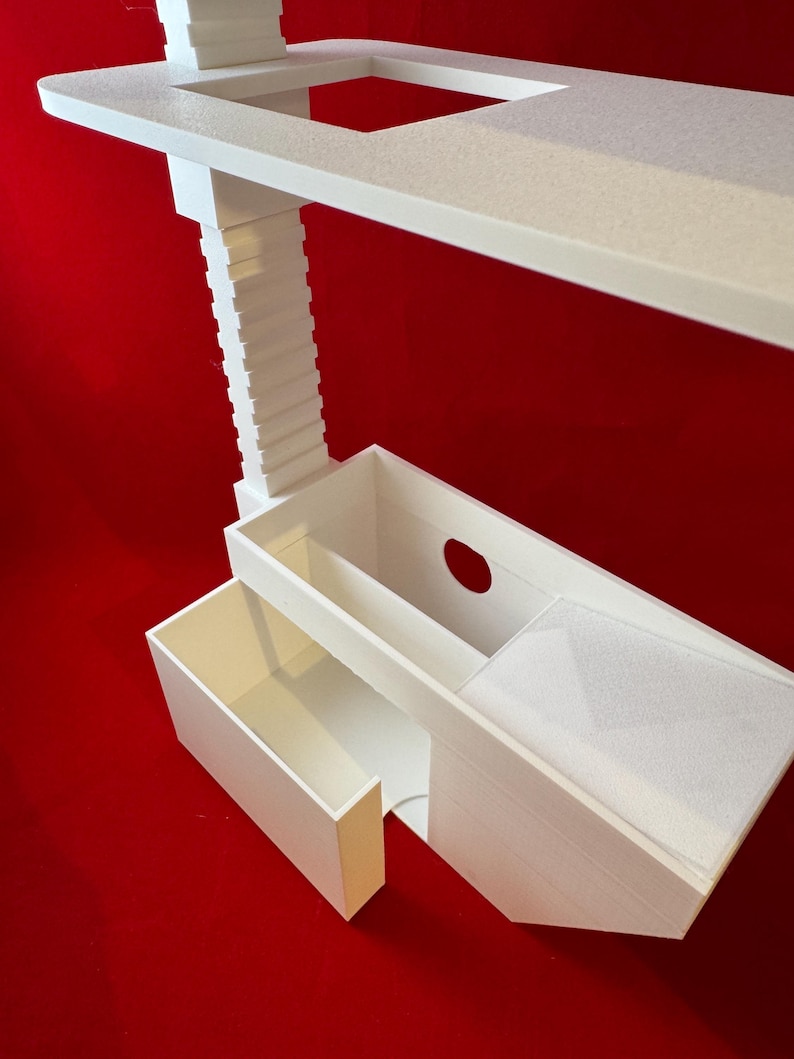 May include: White 3D printed shelf unit with two drawers. The top shelf has a rectangular cutout. The unit is on a red background.