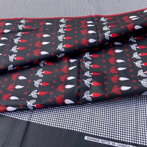 May include: Black fabric with a white and red chili pepper pattern. The fabric has a grid pattern on the back side. The text "KHANGA NZITO YA CHAVDA" is visible on the bottom right corner.