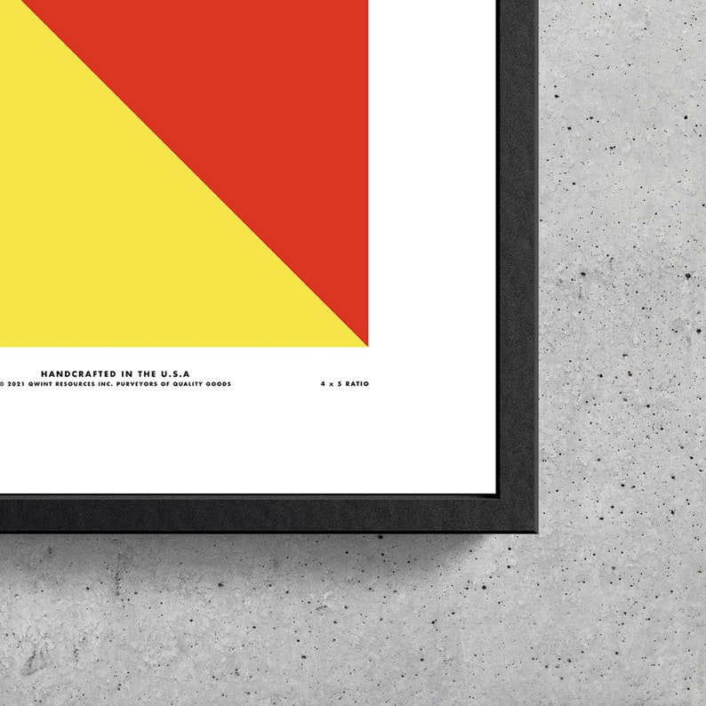 May include: A framed print with a red and yellow geometric design. The print has the text "HANDCRAFTED IN THE U.S.A" and "2021 GWINT RESOURCES INC. PURVEYORS OF QUALITY GOODS" at the bottom. The print also has the text "4 x 5 RATIO" at the bottom right.
