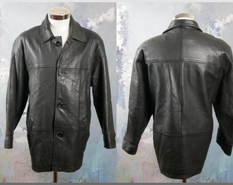 May include: A black leather jacket with a button-up front and a long, straight cut. The jacket has a collar and two pockets on the front.