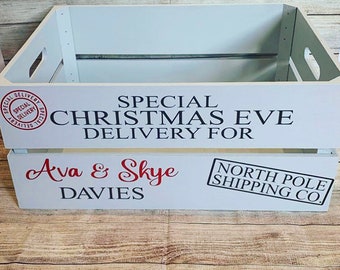 May include: White wooden crate with a red and black Christmas Eve delivery label. The label says "Special Christmas Eve Delivery for Ava & Skye Davies" and "North Pole Shipping Co."