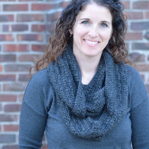 Smiling woman wearing a charcoal sweater and handmade infinity scarf
