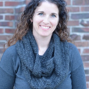 Smiling woman wearing a charcoal sweater and handmade infinity scarf