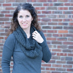 Smiling woman wearing a charcoal sweater and handmade infinity scarf
