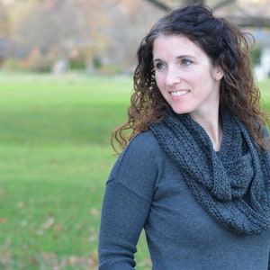 Smiling woman wearing a charcoal sweater and handmade infinity scarf
