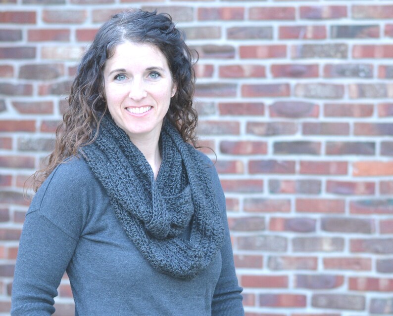 Smiling woman wearing a charcoal sweater and handmade infinity scarf
