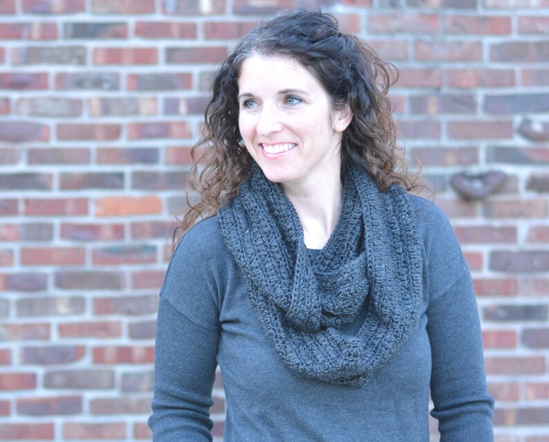 Smiling woman wearing a charcoal sweater and handmade infinity scarf