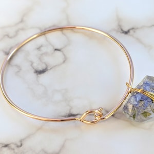 Gold bangle with one flower charm