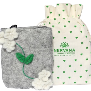 May include: A gray felt pouch with white felt flowers and green felt leaves. The pouch is in a white cotton drawstring bag with green hearts and the text "NERVANA Empowering Women HAND MADE IN NEPAL".