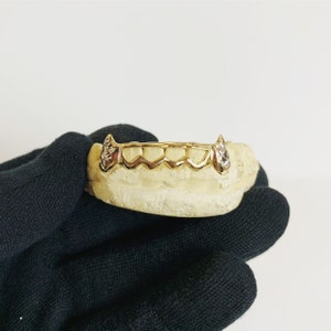 6 teeth (Rhodium cuts on fangs, inner 4 half open face)