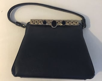 Vintage Caprice Black textured  leather purse with black and gold tone decorative metal clasp.