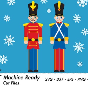 May include: Two toy soldier nutcrackers with red and blue uniforms, standing against a blue background with white snowflakes. The text "Machine Ready Cut Files" and "SVG - DXF - EPS - PNG - JPEG" is at the bottom of the image.