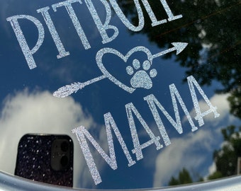 Pode incluir: Adesivo de carro de glitter prateado com o texto "Pitbull Mama" e uma pegada dentro de um coração com uma flecha apontando para a direita.