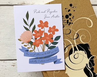 Puede incluir: Una tarjeta blanca con una ilustración floral y el texto "Pride and Prejudice Jane Austen" y una cinta azul con el texto "You must allow me to tell you how ardently I admire and love you."