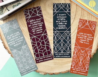 May include: Four bookmarks with geometric patterns and quotes from F. Scott Fitzgerald. The quotes are: "In any case you mustn't confuse a single failure with a final defeat." "I don't want to repeat my innocence. I want the pleasure of losing it again." "I wasn't actually in love, but I felt a sort of tender curiosity." "Life starts all over again when it gets crisp in the fall."