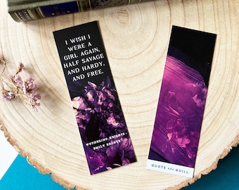 May include: Two purple and black bookmarks with floral designs. One bookmark features a quote from "Wuthering Heights" by Emily Brontë: "I wish I were a girl again, half savage and hardy, and free." The other bookmark has the text "Quote and Quill".