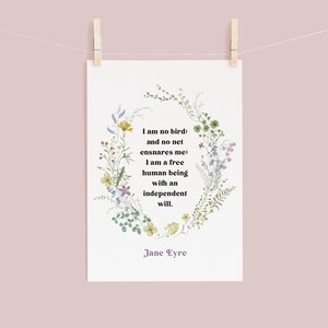 May include: A white card with a floral wreath border and a quote from Jane Eyre: "I am no bird: and no net ensnares me; I am a free human being with an independent will."