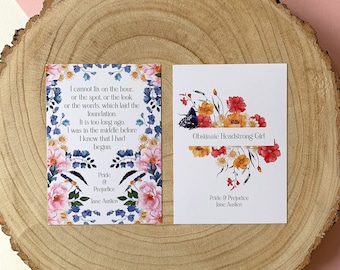 Puede incluir: Dos tarjetas con estampado floral con citas de Orgullo y Prejuicio de Jane Austen. La primera tarjeta presenta una cita sobre la base de algo. La segunda tarjeta presenta una cita sobre una chica testaruda.