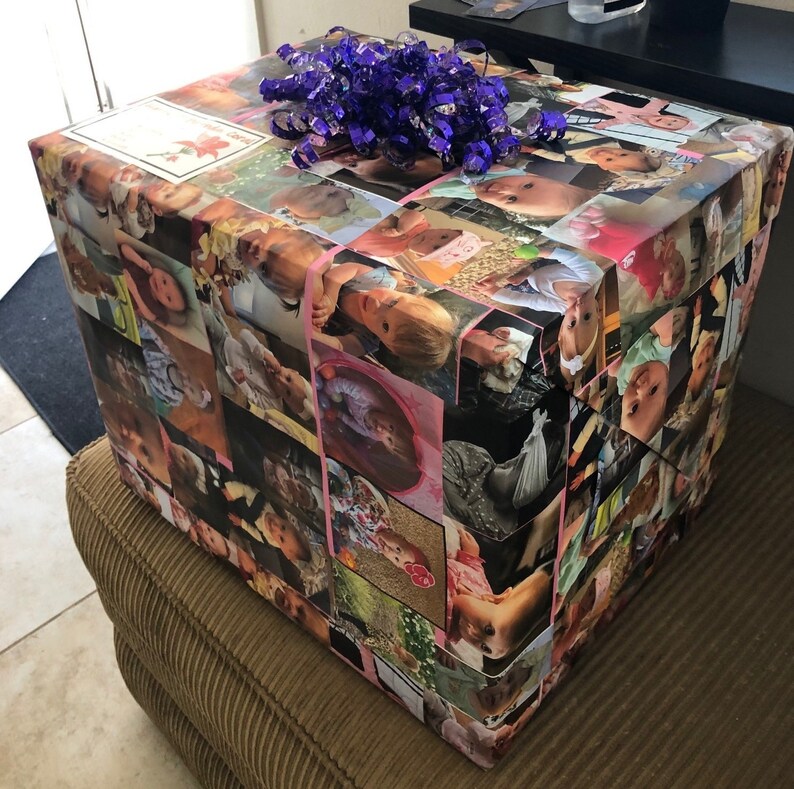 Op de afbeelding: Een cadeaudoos ingepakt in kleurrijk papier met een collage van foto's van kinderen. De doos is vastgebonden met een paars lint.