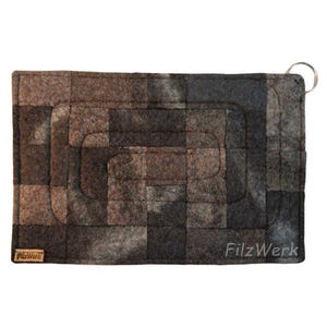 Può includere: Un oggetto rettangolare in feltro con un motivo a scacchiera nei toni del marrone, grigio e nero. L'oggetto presenta un design cucito e un anello di metallo attaccato a un angolo. Il testo "FilzWerk" è visibile sul lato destro.