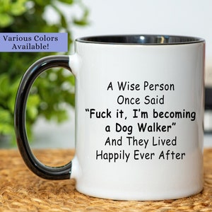 May include: White ceramic coffee mug with a black handle and rim. The mug has a black and white text design that reads "A Wise Person Once Said "Fuck it, I'm becoming a Dog Walker" And They Lived Happily Ever After"