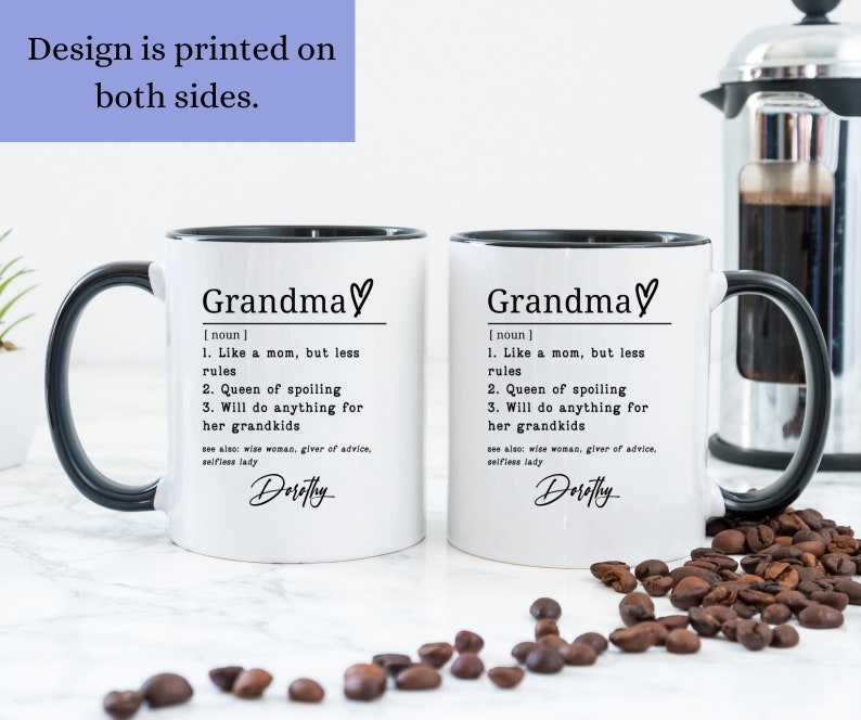 Pu&ograve; includere: Due tazze in ceramica bianca con manici e bordi neri. Le tazze presentano la parola "Grandma" con un simbolo a cuore, una definizione e il nome "Dorothy". &Egrave; visibile anche il testo "Design is printed on both sides".