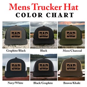 K&ouml;nnte beinhalten: Farbkarte f&uuml;r Trucker-Caps mit verschiedenen Farbkombinationen. Die Caps haben einen braunen Leder-Patch mit dem Wort "DAD" in schwarzer Schrift. Die Farbkombinationen umfassen Graphit/Schwarz, Schwarz, Moos/Anthrazit, Marine/Wei&szlig;, Schwarz/Graphit und Braun/Khaki.
