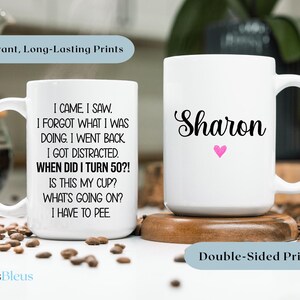 Puede incluir: Dos tazas de cer&aacute;mica blanca con texto negro y un coraz&oacute;n rosa. La taza de la izquierda dice "Vine, vi. Olvid&eacute; lo que estaba haciendo. Volv&iacute;. Me distraje. &iquest;Cu&aacute;ndo cumpl&iacute; 50 a&ntilde;os? &iquest;Es esta mi taza? &iquest;Qu&eacute; est&aacute; pasando? Tengo que ir al ba&ntilde;o." La taza de la derecha dice "Sharon".