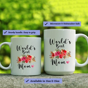 May include: Two white ceramic mugs with black text and floral designs. The larger mug reads "World's Best Mom" and the smaller mug reads "World's Best Mom". Both mugs have a pink heart design. The mugs are microwave and dishwasher safe.