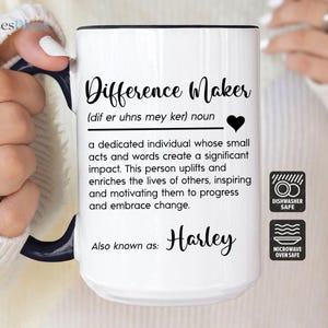 May include: White ceramic mug with black text that reads "Difference Maker (dif er uhns mey ker) noun a dedicated individual whose small acts and words create a significant impact. This person uplifts and enriches the lives of others, inspiring and motivating them to progress and embrace change. Also known as: Harley" with dishwasher and microwave safe icons.