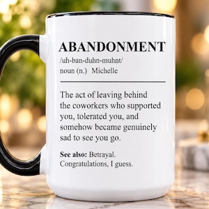 May include: A white ceramic mug with a black handle and rim, featuring black printed text that defines the word ABANDONMENT as the act of leaving behind coworkers who supported you, tolerated you, and became sad to see you go, ending with Congratulations, I guess.