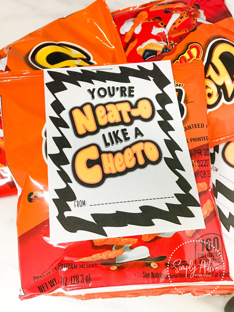 May include: A printable Valentine's Day card with the text "You're Neat-o Like a Cheeto" on a white background with black and orange borders. The card is placed on top of a bag of Cheetos.