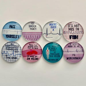 May include: Set of ten round glass magnets with colourful backgrounds and white text. The magnets feature humorous medical-themed sayings, including "Pace Yourself!" and "Two red blood cells fell in love. It was all in vein!"