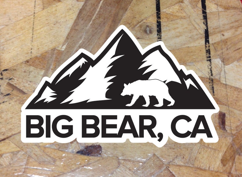 May include: Black and white sticker with a silhouette of a bear walking in front of a mountain range. The text "BIG BEAR, CA" is printed below the image.
