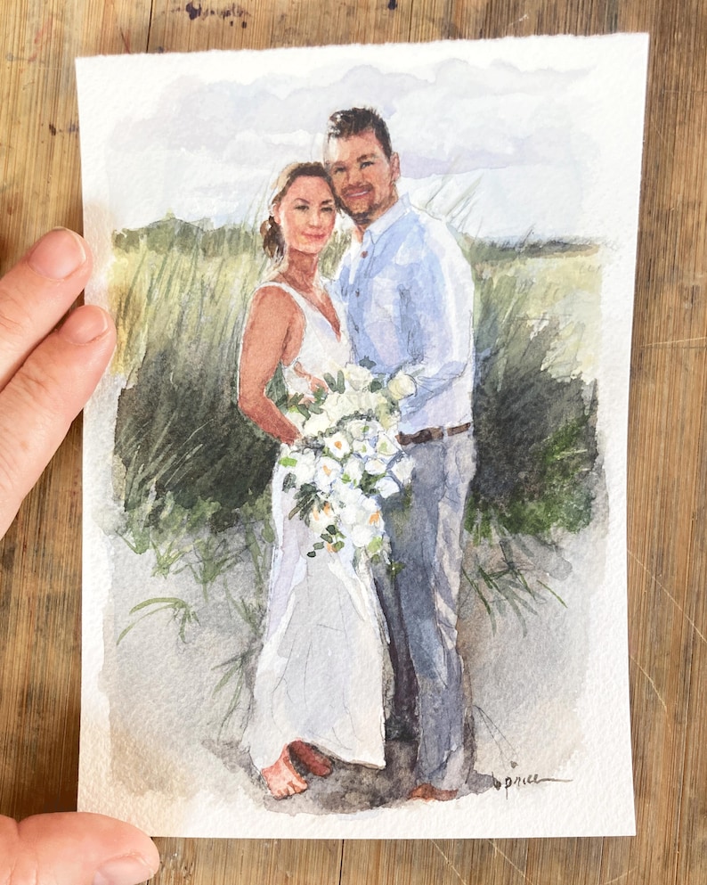 May include: Watercolor painting of a couple embracing, set against a backdrop of tall grass and a cloudy sky. The woman wears a white dress and holds a bouquet. The man is in a light blue shirt and gray pants. The artwork is signed.