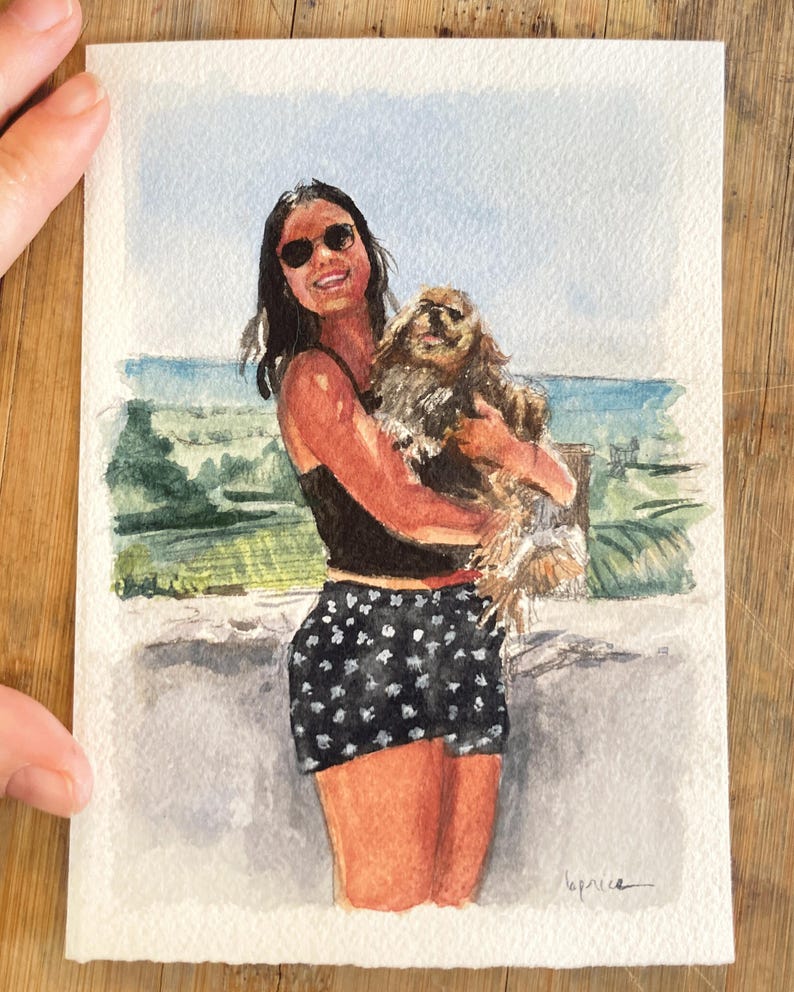 May include: Watercolor painting of a person holding a dog, with a background of a beach scene. The person is wearing sunglasses, a black top, and black shorts with white polka dots. The dog is brown and fluffy.