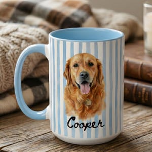 Op de afbeelding: Een keramische mok met een verticaal gestreept patroon in lichtblauw en wit. De voorzijde toont een gedetailleerde illustratie van een golden retriever met de tong uit de bek en een halsbandpenning. Onder de hond staat de naam Cooper in zwart.