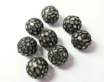 May include: Ten round black beads with a silver metal frame and small white diamonds set into the frame.