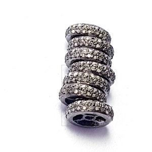 Pode incluir: Uma pilha de seis anéis pretos com pequenos diamantes engastados em cada anel.