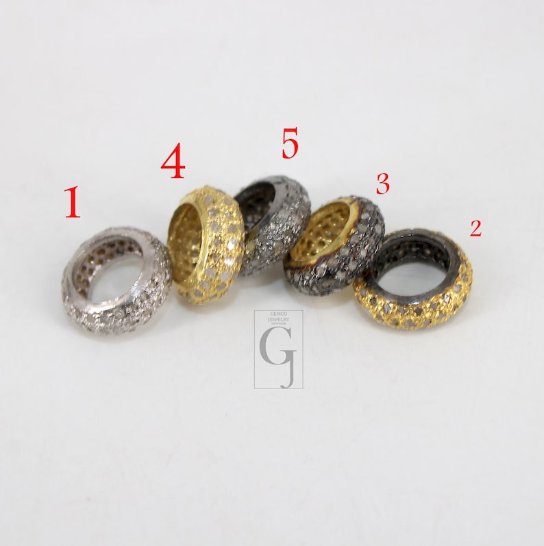May include: Five silver and gold rings with a diamond-like pattern. The rings are stacked on top of each other. The rings are numbered 1 through 5.