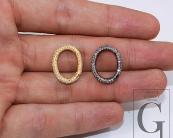 May include: Two oval-shaped connector charms with a pave setting of clear cubic zirconia stones. One charm is gold-toned and the other is silver-toned.