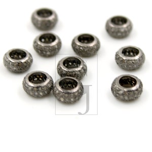 May include: Ten silver-toned round beads with a pave diamond setting. The beads are approximately 1/2 inch in diameter.