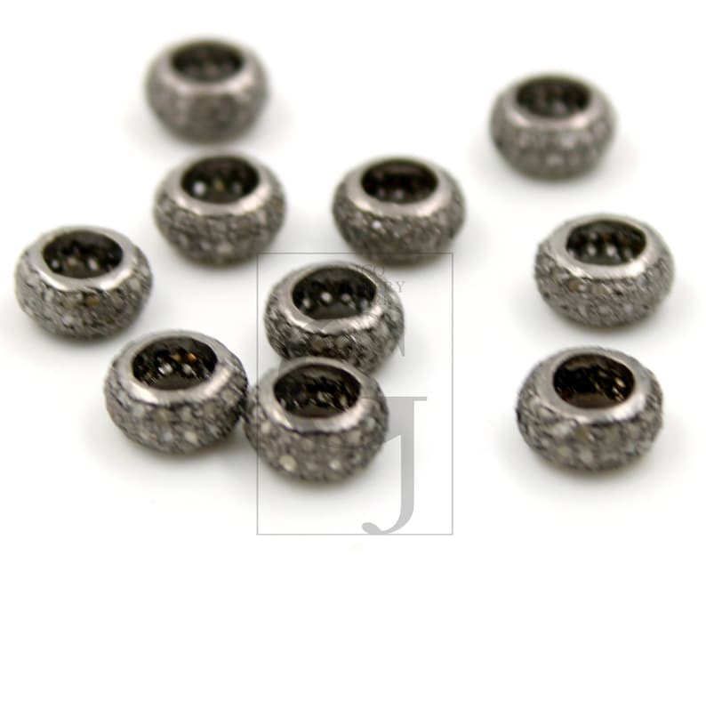 May include: Ten silver-toned round beads with a pave diamond setting. The beads are approximately 1/2 inch in diameter.